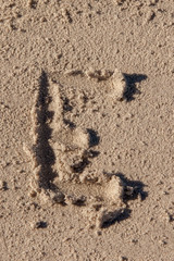 the letter e written in beach sand