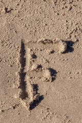 the letter f written in beach sand