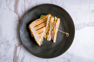 club sandwich with meat on black plate