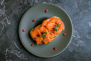 Bruschetta with salmon and cheese on black plate