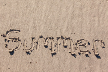 summer written in beach sand