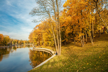 Autumn landscape. Bright golden colors of autumn against the blue sky are reflected in the water of a beautiful full-flowing river.