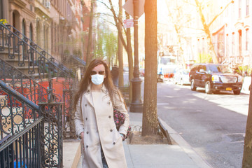Obraz premium Young woman walks in empty New York in a mask protecting from the virus