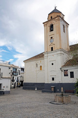 The empty central square and the cathedral with clock tower in the small town in Europe on the sunny day