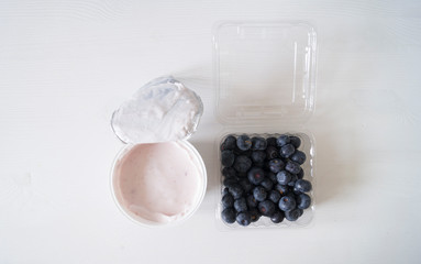 Blueberry yogurt on a white wooden table. Fresh yogurt. Healthy eating concept. High Resolution Product. View from above