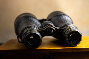Classic binoculars on top of a wooden box.