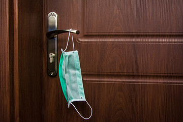 protective mask hangs on the door handle, put the mask on before leaving the house, protection...