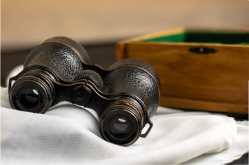 Classic binoculars on top of a white scarf