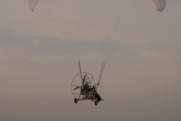 Paraglider on the lake over a sandy beach.