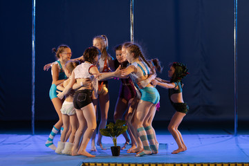 Girls gymnasts show the dance and performance on stage in the theater