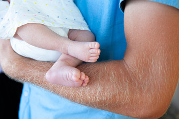 newborn baby feet in dads arm