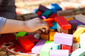 Playing colorful wooden cubes on carpet, sun
