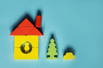A house made of blocks on a blue background. Flat lay with an inspired quote, staying at home...
