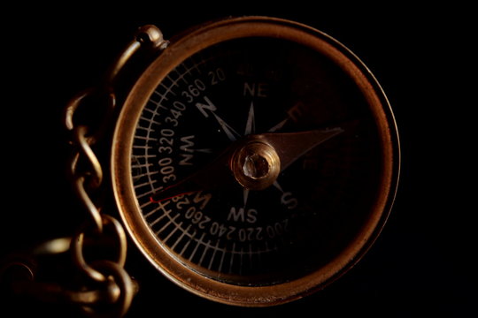 Magnetic compass in a brass case on a black background