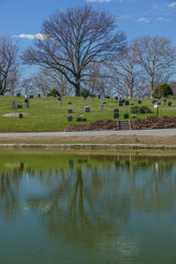 Brooklyn, New York, USA: Trees and headstones reflected in the Valley Water pond at Green-Wood Cemetery.