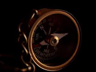 Magnetic compass in a brass case on a black background