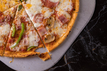 The pizza slices with different toppings in tray on the table.
