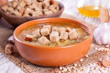 Homemade traditional pea soup with croutons on on table background
