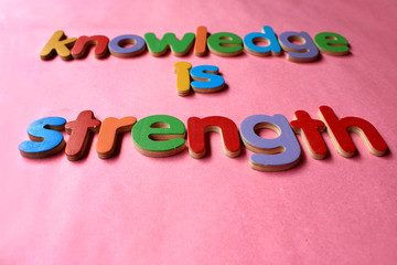 knowledge is strength. Knowledge is strength written on wall by using the wooden English alphabet.