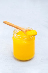 Pure desi ghee in a jar with wooden spoon, copy space