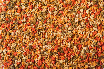 Dry colorful compound fish feed granules background. Top view