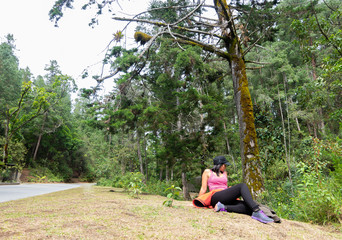 young woman wearing sportswear on grass among trees