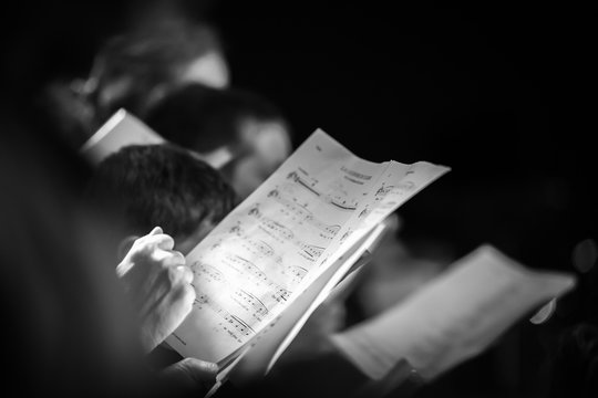 Hand holding music score in choir