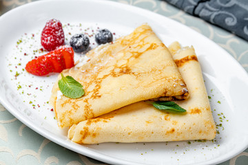 Pancakes with berries on white plate