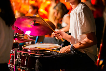 Young drummer playing in orchestra