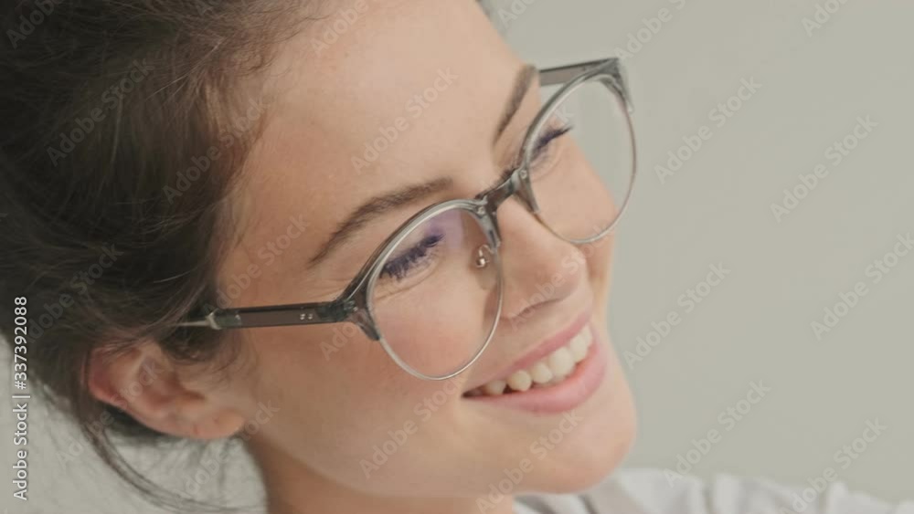 Sticker Pleased pretty brunette woman in eyeglasses making selfie at home