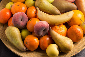 Assorted whole fruit in large bamboo fruit bowl