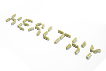 Healthy written with green pills (diagonal down)