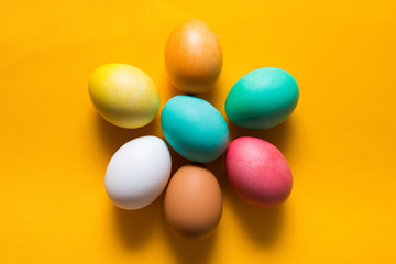 Fototapeta na wymiar Colored easter eggs on a yellow background from above