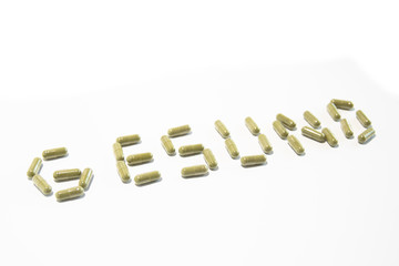 Health written with green pills (german, diagonal up)