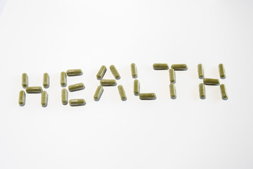 Health written with green pills