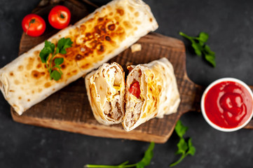 Burrito wraps with chicken and vegetables , against a background of concrete, 
 Mexican shawarma