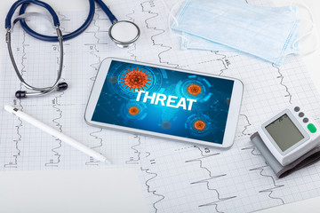 Close-up view of a tablet pc with THREAT inscription, microbiology concept