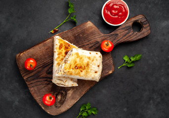 Burrito wraps with chicken and vegetables , against a background of concrete, 
 Mexican shawarma
