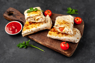 Burrito wraps with chicken and vegetables , against a background of concrete, 
 Mexican shawarma