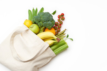 Zero waste food shopping with reusable bags. Flat lay with fruits and vegetables in textile tote...