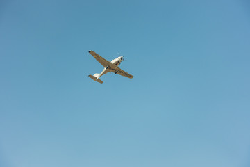 Single sports aircraft flies alone in blue sky. Feeling of freedom and loneliness concept of single-propeller airplane. Place for your text.