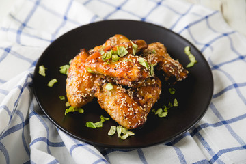 Crispy chicken wings with sesame seeds and chopped herbs