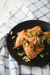 Crispy chicken wings with sesame seeds and chopped herbs