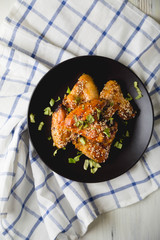 Crispy chicken wings with sesame seeds and chopped herbs