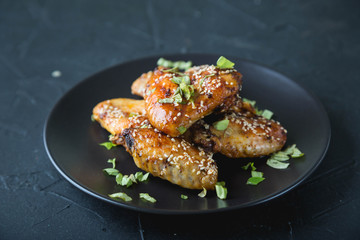 Crispy chicken wings with sesame seeds and chopped herbs