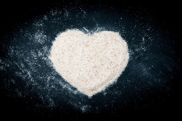Flat lay of heart symbol made of sand