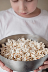 boy holds a bowl of popcorn