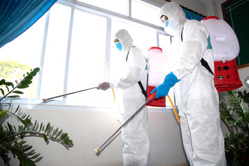 People wearing stairs protective clothing with chemical spray to clean Prevents the spread of...