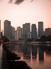 Naklejka premium Skyline of Makati City reflecting in the Pasig River in Metro Manila, Philippines while sunrise