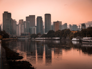 Skyline of Makati City reflecting in the Pasig River in Metro Manila, Philippines while sunrise